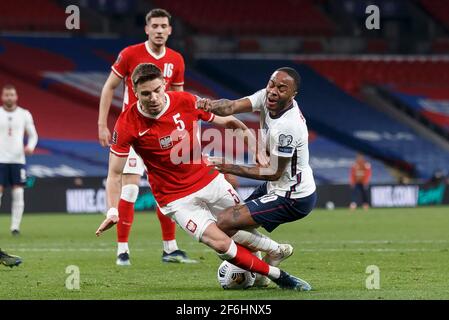 London, Großbritannien. März 2021. Raheem Sterling aus England wird am 31. März 2021 im Wembley-Stadion in London, England, von Jan Bednarek aus Polen im Rahmen des FIFA World Cup 2022 Qualifying Group I-Spiels zwischen England und Polen angegangen. (Foto von Daniel Chesterton/phcimages.com) Quelle: PHC Images/Alamy Live News Stockfoto