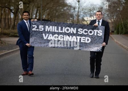 Glasgow, Großbritannien, am 1. April 2021. Douglas Ross, Vorsitzender der schottischen Konservativen und Unionistischen Partei, enthüllt zusammen mit dem Kandidaten und GP Sandesh Gulhane ein Banner über die Einführung des Impfstoffs, als Schottland die 2,5 Millionen Menschen traf, die ihre ersten Does des Covid-19-Coronavirus-Impfstoffs erhielten. Foto: Jeremy Sutton-Hibbert/Alamy Live News Stockfoto