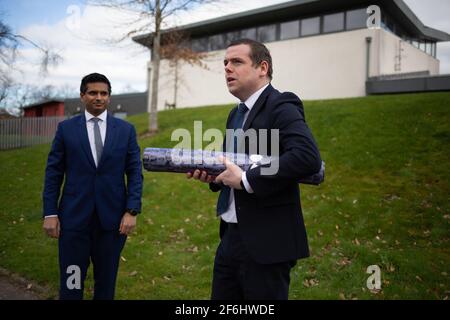 Glasgow, Großbritannien, am 1. April 2021. Douglas Ross, Vorsitzender der schottischen Konservativen und Unionistischen Partei, enthüllt zusammen mit dem Kandidaten und GP Sandesh Gulhane ein Banner über die Einführung des Impfstoffs, als Schottland die 2,5 Millionen Menschen traf, die ihre ersten Does des Covid-19-Coronavirus-Impfstoffs erhielten. Foto: Jeremy Sutton-Hibbert/Alamy Live News Stockfoto