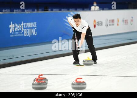 Peking, China. April 2021. Ein Athlet tritt während eines Curling-Testprogramms im National Aquatics Center in Peking am 1. April 2021 an. Zwischen dem 1. Und 10. April 2021 findet ein 10-tägiges Eissport-Testprogramm für die Olympischen und Paralympischen Winterspiele 2022 statt. Dieses Testprogramm soll die Organisation des Wettbewerbs, den Betrieb des Veranstaltungsortes sowie die Dienstleistungen und den Schutz testen. Es wird alle Eissportarten von Peking 2022, nämlich Kurzstrecken-Eisschnelllauf, Eisschnelllauf, Eiskunstlauf, Eishockey, Eisstockschießen, Eisstockschießen, Para Eishockey und Rollstuhl Curling. Quelle: Ju Huanzong/Xinhua/Alamy Live News Stockfoto