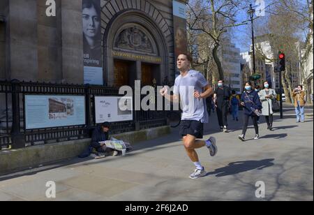 London, England, Großbritannien. Jogger, der an der National Portrait Gallery in St. Martin's Place vorbeiläuft Stockfoto