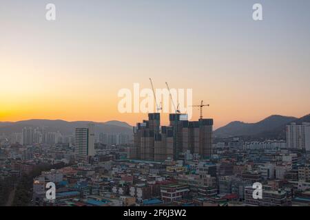 Die Kräne auf der Baustelle Gebäude der Wohnung Morgendämmerung Stockfoto