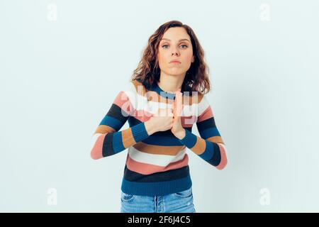 Wütend junge Frau zeigt ihre Faust schlug gegen ihre Handfläche mit ernster Gesichtsausdruck, während sie auf weißem Hintergrund stehen. Stockfoto