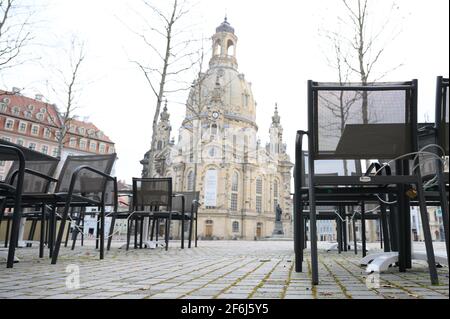 Dresden, Deutschland. April 2021. Tische und Stühle stehen vor einem geschlossenen Restaurant am Neumarkt vor der Frauenkirche. Aufgrund der hohen Anzahl von Corona-Infektionen werden die Relaxationen in Dresden ab dem 01. April 2021 rückgängig gemacht. Quelle: Sebastian Kahnert/dpa-Zentralbild/dpa/Alamy Live News Stockfoto