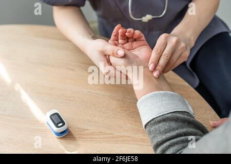 Ein Arzt, der den Puls des Patienten nimmt Stockfoto