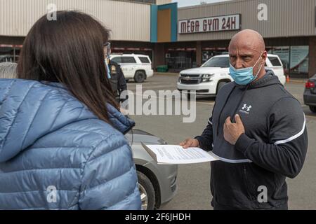 Mitarbeiter von Sécurité Publique überreichen einem Trainer von Mega Gym 24h die offiziellen Dokumente für die obligatorische Schließung seines Fitnessstudios nach einem schweren COVID 19-Ausbruch in Quebec City, 31. März 2021. Stockfoto