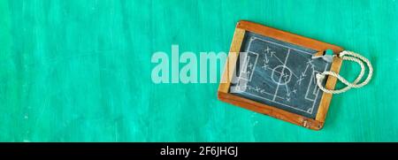 Pfeife eines Fußballtrainers und taktisches Diagramm-Scribble auf schwarzem Brett, Panorama-Flat Lay, grungy-Style, tolles Fußballevent in diesem Jahr Stockfoto