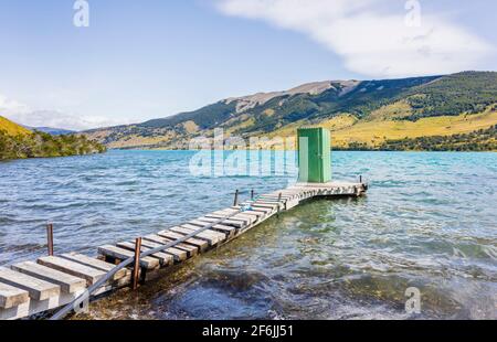 Grüner Toilettenschuppen am Seeufer, der am Ende eines hölzernen Anlegerbodens auf Languna Azul, im Nationalpark Torres del Paine, Patagonien, Südchile, steht Stockfoto