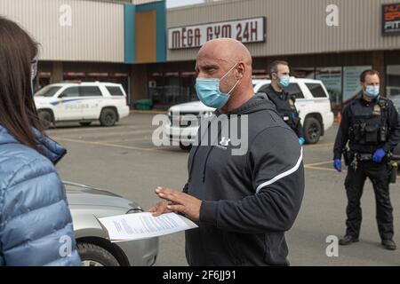 Mitarbeiter von Sécurité Publique überreichen einem Trainer von Mega Gym 24h die offiziellen Dokumente für die obligatorische Schließung seines Fitnessstudios nach einem schweren COVID 19-Ausbruch in Quebec City, 31. März 2021. Stockfoto