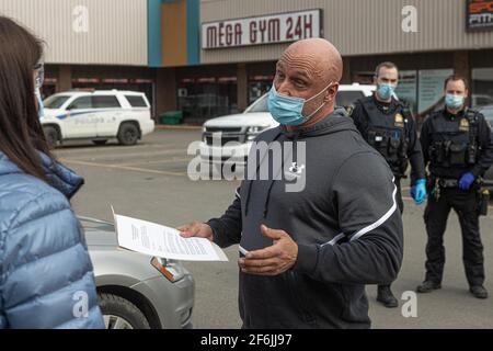 Mitarbeiter von Sécurité Publique überreichen einem Trainer von Mega Gym 24h die offiziellen Dokumente für die obligatorische Schließung seines Fitnessstudios nach einem schweren COVID 19-Ausbruch in Quebec City, 31. März 2021. Stockfoto