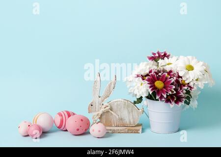 osterkarte blau mit Blumen, Hase und rosa Eiern. Hintergrund mit Kopierplatz Stockfoto