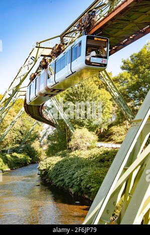 Wuppertal, Nordrhein-Westfalen / Deutschland: Die Wuppertaler Schwebebahn, eine elektrische Hochbahn mit hängenden Autos, folgt dem Wupper. Stockfoto