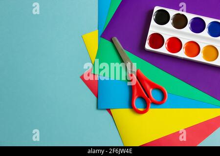 Buntpapier, Karton, Farben, Scheren, Stifte für Kreativität und Basteln mit Kindern. Auf blauem Hintergrund.Schreibwaren, Platz für den Text. Weich Stockfoto