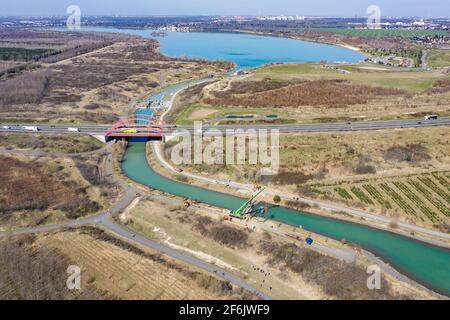 31. März 2021, Sachsen, Markkleeberg: Der Kanal zwischen Markkleeberger See (hinten) und Störmthaler See ist mit einer Pfahlwand verschlossen. Risse im Kanaldamm zwischen den Gewässern erfordern sofortige Sicherungsmaßnahmen. Der 850 Meter lange Störmthal-Kanal verbindet die beiden Seen - die Schleuse, die jetzt von Rutschen im Böschung betroffen ist, kompensiert die Differenz von vier Metern im Wasserstand der Gewässer. Experten zufolge würde ein vollständiger Einsturz zu großflächigen Überschwemmungen führen - in den nördlichen Stadtgebieten von Markkleeberg bis Leipzig. Jetzt tauchen, surfen, sa Stockfoto