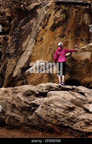 Mädchen, die auf Felsen wandern und Felszeichnungen von Felszeichnungen betrachten Stockfoto