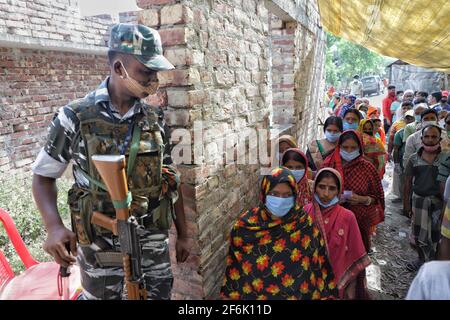 Ein bewaffneter Offizier der zentralen Streitkräfte steht am Eingangstor eines Wahlkabins in East Midnapur.die Wähler von Nandigram haben während der zweiten Phase der Parlamentswahlen in Westbengalen ihre Stimme abgegeben, um die Wahlen friedlich zu gestalten. Stockfoto
