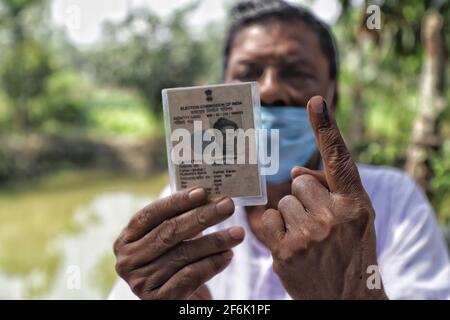 Nandigram, Indien. April 2021. Ein Mann zeigt seinen Finger und den Personalausweis des Wählers, nachdem er seine Stimme bei East Midnapur abgegeben hat.die Wähler von Nandigram haben ihre Stimme während der zweiten Phase der Parlamentswahlen in Westbengalen abgegeben, die von schweren bewaffneten Zentraltruppen eingesetzt wurden, um die Wahlen friedlich zu gestalten. (Foto von JIT Chattopadhyay/SOPA Images/Sipa USA) Quelle: SIPA USA/Alamy Live News Stockfoto