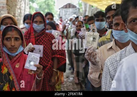 Nandigram, Indien. April 2021. Menschen, die ihre Wählerausweise vorzeigen, während sie in Warteschlangen vor einem Wahlstand in East Midnapur warten.die Wähler von Nandigram haben während der zweiten Phase der Parlamentswahlen in Westbengalen ihre Stimme abgegeben, um die Wahlen friedlich zu gestalten. (Foto von JIT Chattopadhyay/SOPA Images/Sipa USA) Quelle: SIPA USA/Alamy Live News Stockfoto