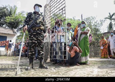 Nandigram, Indien. April 2021. Ein bewaffneter Offizier der zentralen Streitkräfte steht am Eingangstor eines Wahllokals in einer Schule in East Midnapur.die Wähler von Nandigram haben während der zweiten Phase der Parlamentswahlen in Westbengalen ihre Stimme abgegeben, um die Wahlen friedlich zu gestalten. (Foto von JIT Chattopadhyay/SOPA Images/Sipa USA) Quelle: SIPA USA/Alamy Live News Stockfoto