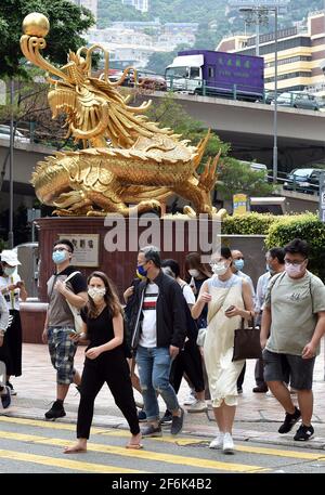 Hongkong, China. April 2021. Menschen mit Gesichtsmasken gehen auf einer Straße in Hongkong, Südchina, 1. April 2021. Das Hongkonger Zentrum für Gesundheitsschutz (CHP) meldete am Donnerstag 13 weitere bestätigte Fälle von COVID-19, was einer Gesamtzahl von 11,480 entspricht.von den neuen Fällen wurden 11 importiert und zwei wurden lokal übertragen und hatten unbekannte Ursprünge, so eine Stellungnahme des CHP. Quelle: Lo Ping Fai/Xinhua/Alamy Live News Stockfoto