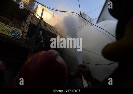 Rawalpindi, Pakistan. April 2021. Blick auf die Brandszene, nachdem ein Brand aufgrund eines elektrischen Kurzschlusses ausgebrochen war, da die Feuerwehrbeamten auf dem Basar Urdu, Rawalpindi, mit dem Löschen von Wasser beschäftigt sind. (Foto: Zubair Abbasi/Pacific Press) Quelle: Pacific Press Media Production Corp./Alamy Live News Stockfoto