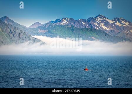 Nebel, der die Berge in Alaska aufsteigt, vom offenen Wasser aus gesehen Stockfoto