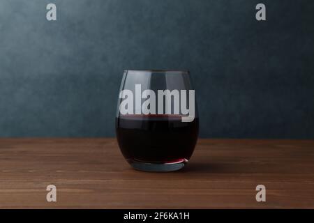 Glas Rotwein isoliert auf Holztisch Stockfoto