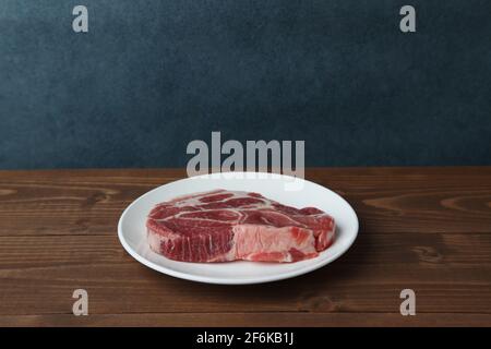 Rohes Schweinefleisch isoliert auf Holztisch Stockfoto