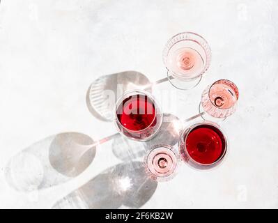 Wein verschiedener Sorten auf hellem Beton-Hintergrund. Viele verschiedene Gläser Wein. Konzept der Weinprobe. Draufsicht, flach liegend Stockfoto