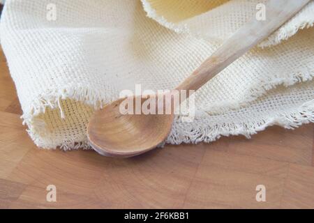 Holzlöffel und Serviette auf Schneidebrett Stockfoto