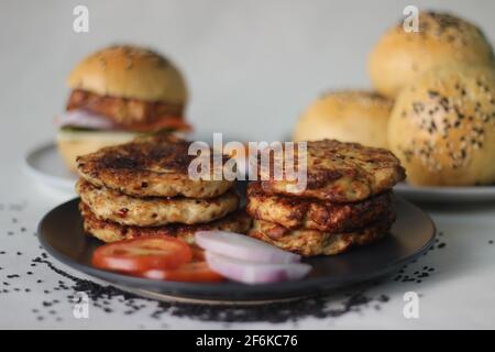 Hähnchenburger. Zubereitet mit hausgemachtem Hähnchenpatty, Zwiebeln, Jalapeno und Käse, eingeklemmt in hausgemachten Burger-Brötchen. Aufgenommen auf weißem Hintergrund Stockfoto