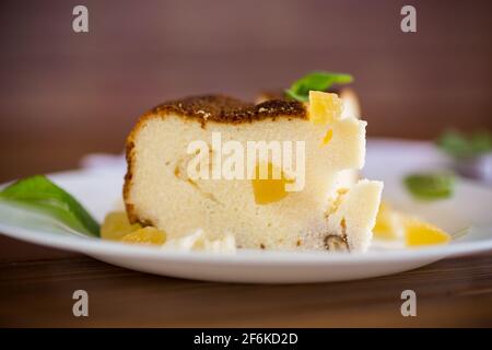 Süß gebackener Hüttenkäse-Auflauf mit Nüssen und kandierten Früchten Auf einem Holztisch Stockfoto
