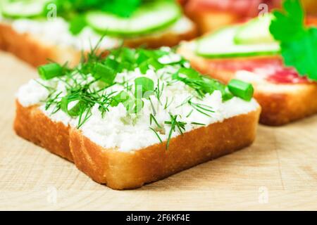 Sandwich mit Weichkäse und Kräutern, Holztisch, Nahaufnahme Stockfoto