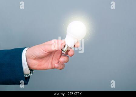 Ein Mann, der eine Glühbirne in der Hand hält. Konzeptbild über neue Idee, Inspiration, Geschäft Stockfoto