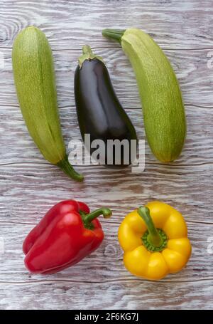 Gemüse, Auberginen, Zucchini und Paprika auf einem hölzernen Hintergrund, flach legen Stockfoto