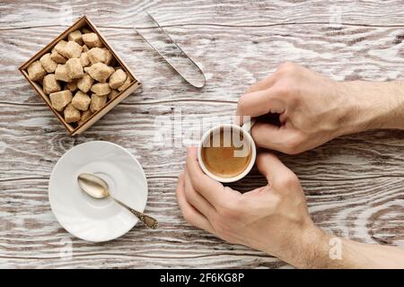Mans Hände halten Tasse Kaffee auf dem Holztisch Stockfoto