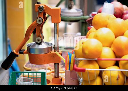Entsafter mit vielen reifen Orangen im Freien auf dem Straßenmarkt in Jerusalem, Israel aus der Nähe Stockfoto