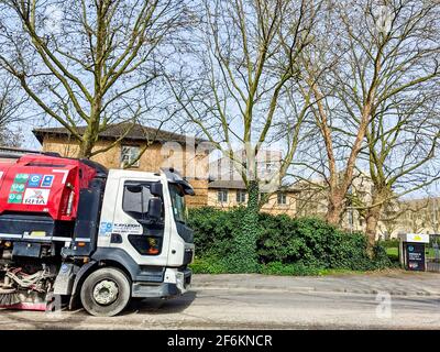 Ein rot-weißer Kehrwagen zur Reinigung von Schmutz von der Straße. Stockfoto