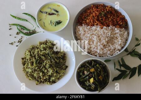 Vegetarisches Essen im Kerala-Stil, einschließlich gekochtem matta-Reis, rotem Karotten-Thoran, Bohnen-Rührbraten, grüner Gramm-Flasche Kürbis-Thoran und temperierter Buttermilch. Aufgenommen Stockfoto