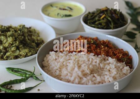 Vegetarisches Essen im Kerala-Stil, einschließlich gekochtem matta-Reis, rotem Karotten-Thoran, Bohnen-Rührbraten, grüner Gramm-Flasche Kürbis-Thoran und temperierter Buttermilch. Aufgenommen Stockfoto