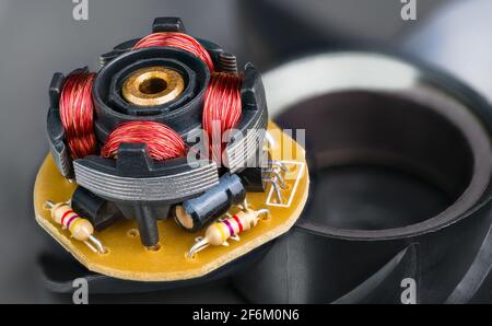 Rotor des elektronisch kommutierten Motors des Computerlüfters. Nahaufnahme von Kupferdrahtwicklung, Widerständen, Transistoren oder Kondensatoren in der elektrischen Maschine. Stockfoto