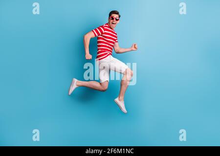 In voller Länge Körper Seitenprofil Foto glücklich Mann springen hoch Schnelle, isolierte Ausführung auf hellblauem Hintergrund Stockfoto