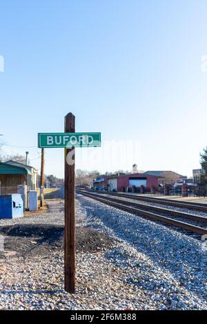 Stadtschild mit dem Namen der Stadt Buford neben den Bahngleisen, im Bundesstaat Georgia Stockfoto