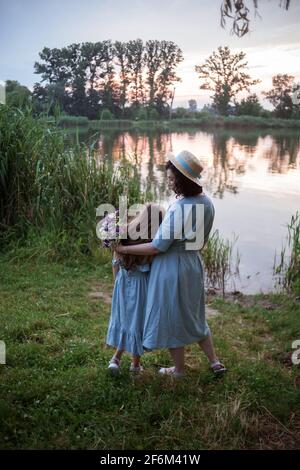 Die Mutter umarmt ihre Tochter im Freien in der Natur Stockfoto