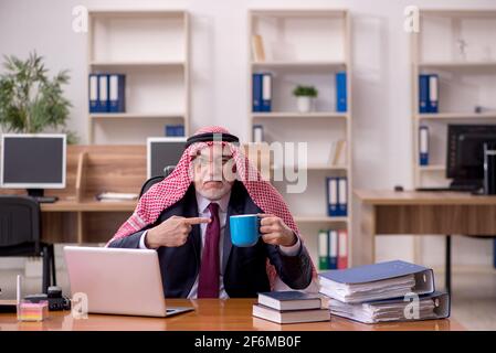 Gealterter arabischer Angestellter, der während der Pause Kaffee trinkt Stockfoto