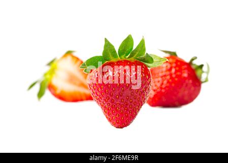 Wenige reife Erdbeeren Spaniens isoliert auf weißem Hintergrund. Frische Bio-Erdbeere aus Griechenland, in Scheiben geschnitten Stockfoto