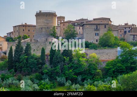 Die Skyline der kleinen Stadt Gualdo Cattaneo, Terni, Italien, auf einem Hügel mit Bäumen und blauem Himmel Stockfoto