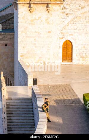 Zwei Anti-Terror-Soldaten warten auf die Ankunft von Touristen und Pilgern vor der berühmten oberen Basilika San Francesco in Assisi, Umbrien, Italien Stockfoto