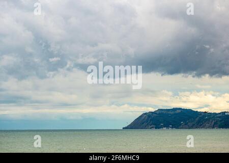 Das Vorgebirge von Gabicce ragt nach einem Sturm in die Adria, dunkle Wolken am Himmel Stockfoto