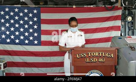 US Navy Cmdr. Kimberly Jones, der neue Kommandant des Anlegeschiffs USS Tortuga der Whidbey Island-Klasse, wendet sich während der Befehlswechselzeremonie am 16. Juli 2020 in Virginia Beach, Virginia, an die Besatzung. Stockfoto